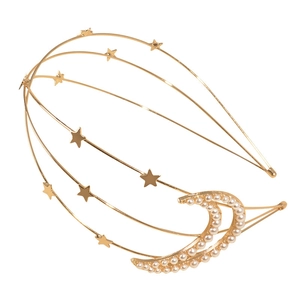 Macro detail of golden multi-layer headband with pearls and metallic stars and moon