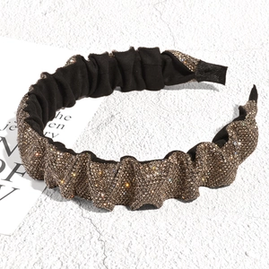 Macro shot of pleated headband featuring full champagne rhinestones and soft inner lining
