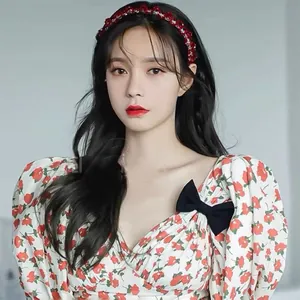Détail d'un serre-tête fait main en perles de cristal rouge et robe florale à manches bouffantes