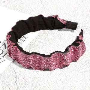 Detail of rose pink rhinestone headband featuring pleated texture and black non-slip lining