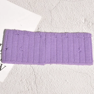 Vue détaillée du bandeau en maille côtelée violette avec textures à pompons décoratifs