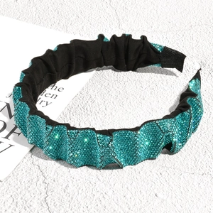 Detail view of turquoise rhinestone pleated headband with vintage sparkle texture