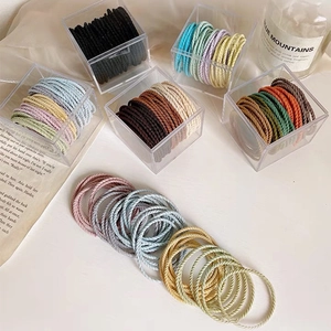 Macro shot of 50 durable high-elastic colorful hair ties stored in a clear acrylic box
