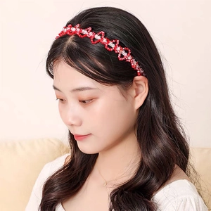 Détail d'un serre-tête en perles rouges et blanches avec motif cœur sur un mannequin