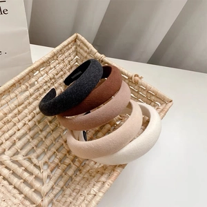 Detail of 5-piece thick sponge headbands set in earth tones inside a woven basket