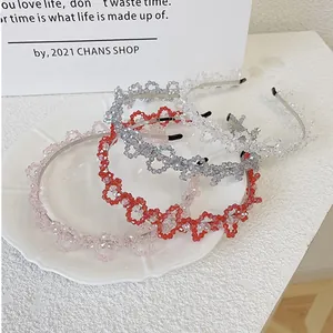 Détail de quatre serre-têtes en perles de cristal rose, rouge et argent sur assiette blanche
