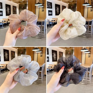 Detail von Organza-Haargummis in Rosa, Beige, Grau und Schwarz mit feinem Glitzereffekt