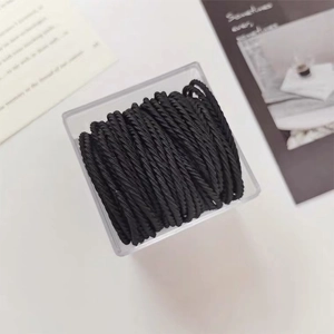Close-up of black spiral hair ties neatly organized in a transparent storage box