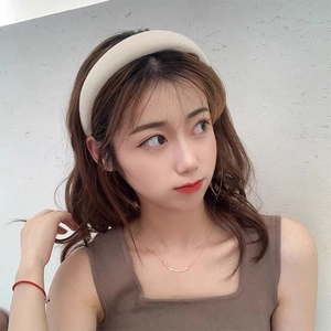 Detailed close-up of cream-colored padded sponge headband worn by a model