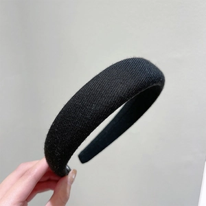 Detail view of the thick black sponge headband with ribbed fabric texture and padded design