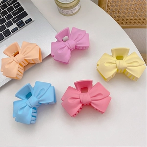 Cinq pinces à cheveux en forme de nœud aux couleurs macaron mates comme l'orange et le rose