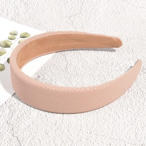 Detail view of light pink padded faux leather headband with textured surface and non-slip lining
