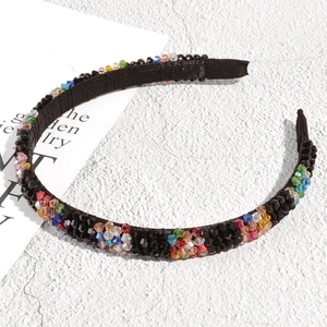 Close-up of vibrant multi-colored crystal rhinestones on a slim black metal headband