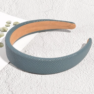 Detail view of navy blue leather headband with pebble texture and khaki fabric lining