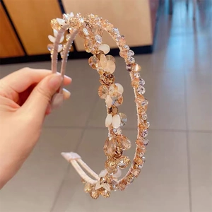 Détail d'un serre-tête double rangée orné de cristaux champagne et de strass brillants