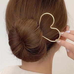 Pic à cheveux doré en forme de cœur pour chignon élégant sur cheveux châtains