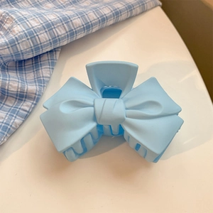 Détail de la pince à cheveux noeud bleu clair mat avec design à dents multiples
