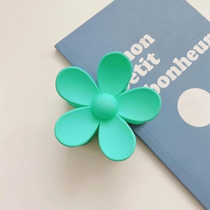 Detail of a mint green matte flower hair claw clip with a subtle frosted texture