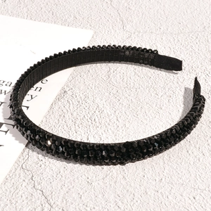 Close-up of black rhinestone headband showing intricate crystal details and fabric inner lining