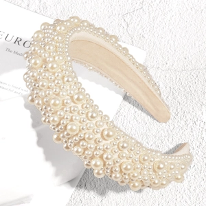 Detailed close-up of thick cream sponge headband with varying sizes of round faux pearls