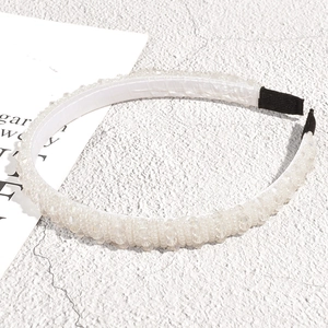 Close-up of white beaded headband with rows of crystals and non-slip black ends
