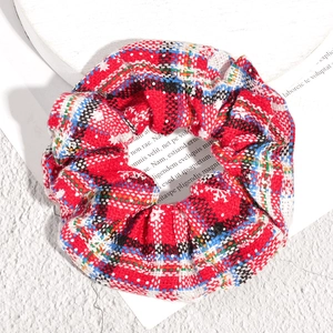 Christmas plaid scrunchie with red tartan pattern and snowflake print for holiday hair styling