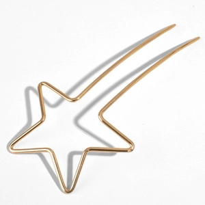 Détail d'une épingle à cheveux étoile dorée en métal au design minimaliste moderne