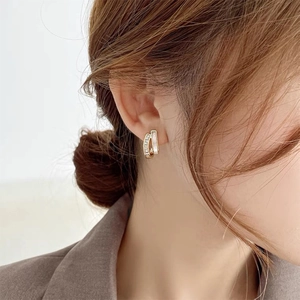 Elegant gold geometric earrings with pavé zircons and white shell inlay on model