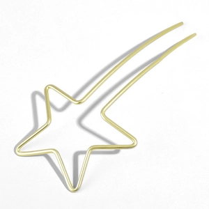 Détail d'un pic à cheveux étoile dorée minimaliste avec double griffes sur fond blanc uni