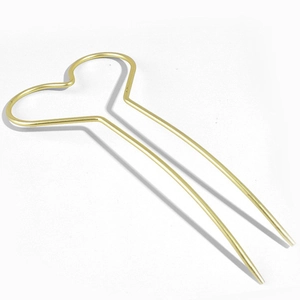 Détail d'une épingle à cheveux cœur en métal doré avec une double broche en forme de U
