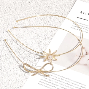 Golden bow headband set with rhinestones and pearl accents on a minimalist background