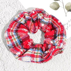 Detail of red plaid Christmas scrunchie with snowflake patterns on fabric