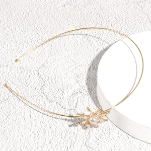 Elegant gold metal headband featuring a radiant sunburst charm with a large central pearl