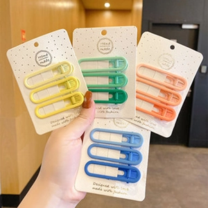 Dettaglio di set di fermagli opachi colorati in giallo, menta, rosa e blu scuro