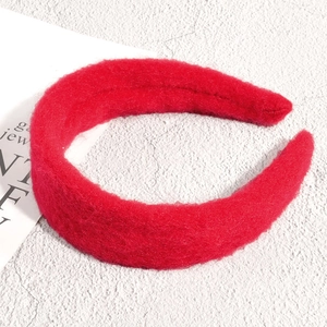 Gros plan d'un serre-tête rouge épais en peluche avec texture douce en fausse fourrure