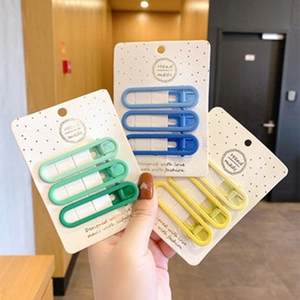 Dettaglio di fermagli per capelli opachi fatti a mano in blu verde e giallo su carta