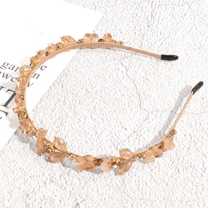 Detailed close-up of champagne crystal headband with elegant beads on a metallic frame