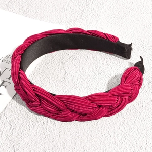 Détail de la structure tressée d'un serre-tête en satin rouge foncé avec doublure noire