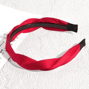 Vue détaillée d'un serre-tête torsadé rouge avec design antidérapant et texture satinée