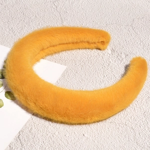 Vue détaillée d'un serre-tête en peluche jaune vif avec une texture douce en fausse fourrure