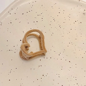 Détail d'une mini pince à cheveux en forme de cœur floquée sur une assiette en céramique