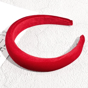 Gros plan sur un serre-tête en velours rouge avec texture tressée vintage et design rembourré