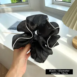 Detail view of large 18cm black mesh hair scrunchie with white piped edges