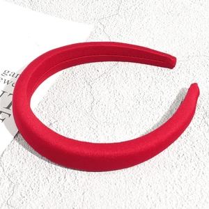Vue détaillée d'un serre-tête rouge épais rembourré avec une texture de tissu brillant