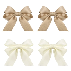 Detail of four-piece ribbon bow hair clips in champagne gold and off-white satin
