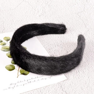 Detail view of plush black faux fur headband with soft texture and solid winter design