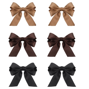 Detail of 6-piece ribbon bow hair clips set in camel, brown and black colors