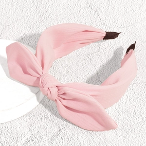 Close-up of pink bow headband featuring soft fabric texture and knotted knot design