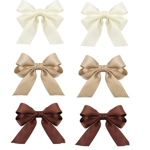 Set of 6 ribbed fabric bow hair clips in cream, champagne and brown on white background