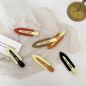 Elegant minimalist matte duckbill hair clips set in earthy tones on artistic paper background